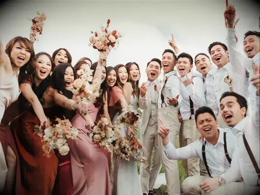 Bride and groom posing with groomsmen and bridesmaids