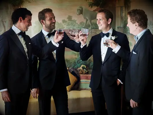 Groom and groomsmen toasting before the wedding ceremony