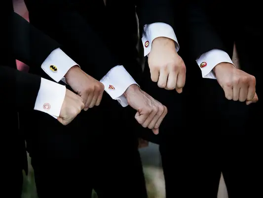 Groomsmen showing off superhero cufflinks