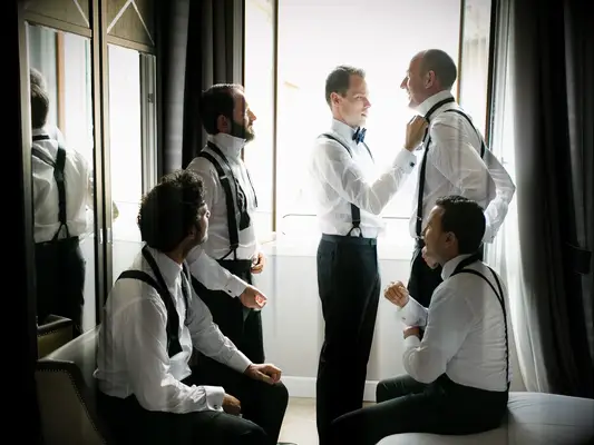 Groomsmen getting ready with groom on wedding morning
