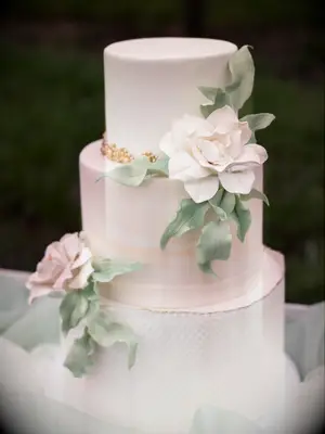 elegant ivory and blush fondant wedding cake with blush sugar flowers and greenery leaves