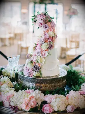 white buttercream flower wedding cake with purple cascading roses
