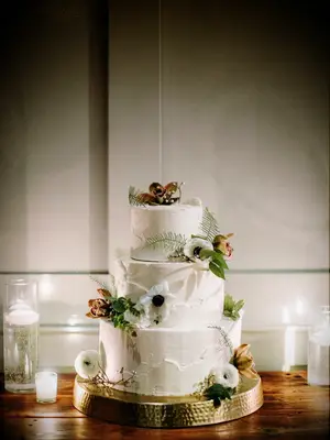 three tier buttercream wedding cake with white anemones and greenery