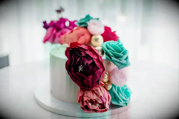 Single-Tier White Cake With Colorful Flowers in Blue, Pink and Red With Gold Accents