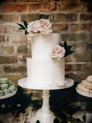 two tier white wedding cake with blush roses