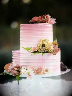 two tier pink wedding cake with sliced grapefruits, figs and blush flowers