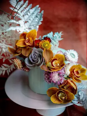 one tier wedding cake with light blue fondant orange orchids and painted greenery