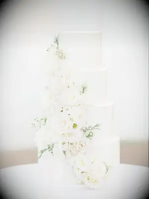 four tier white wedding cake with ivory cascading roses