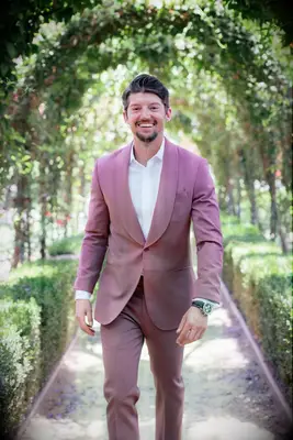 A model wears this stunning modern tux in a shade of dusty rose.