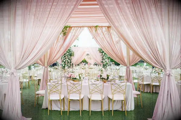 Pink draping provides a romantic aesthetic to this outdoor reception space.