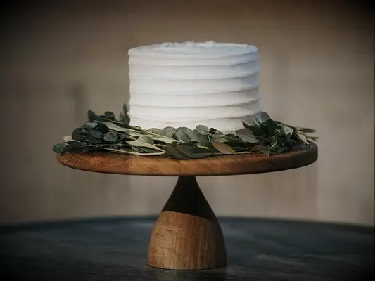 Single-tier rustic cutting cake with white icing and eucalyptus leaves