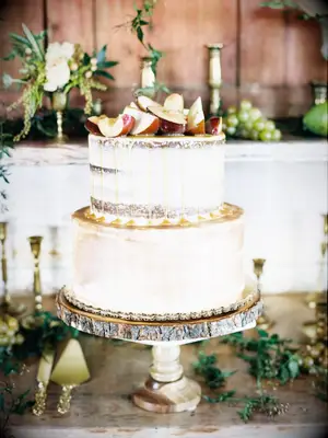 Two-tier rustic cake with apple slices and caramel drizzle on top