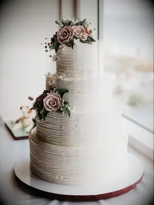 Rustic white wedding cake with light pink sugar flowers
