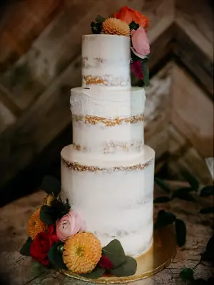 Rustic wedding cake with white semi-naked icing and mismatched tier heights