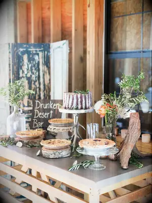 rustic wedding dessert table with pies, naked cake and greenery arrangements