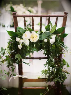 brown chiavari chair with floral swag of greenery and white flowers