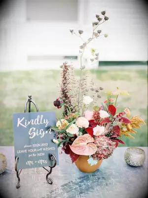handwritten welcome sign next to modern fall wedding flower arrangement