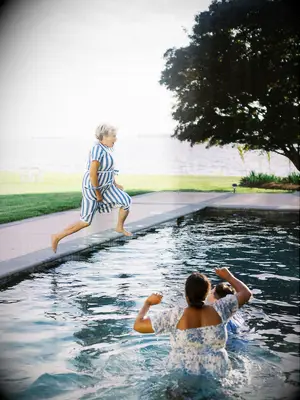 A parent of the happy couple jumps into a swimming pool