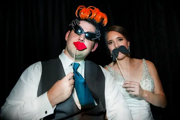 The bride and groom take a silly photo booth picture