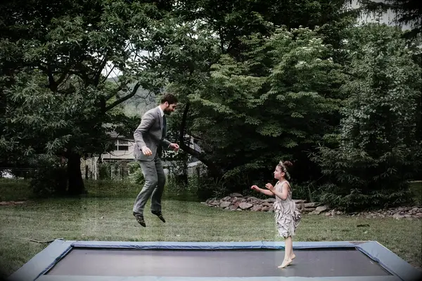 A couple of wedding guests jump on a trampoline