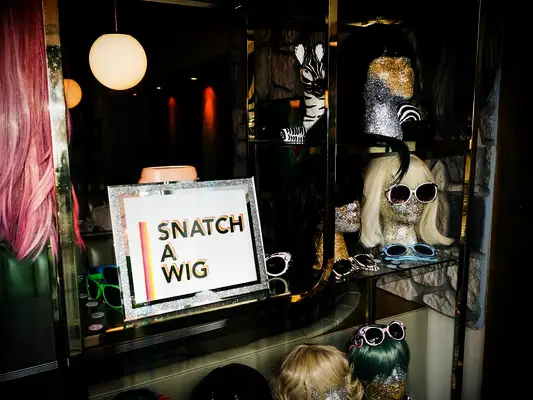 Wig wall at a Halloween-themed wedding