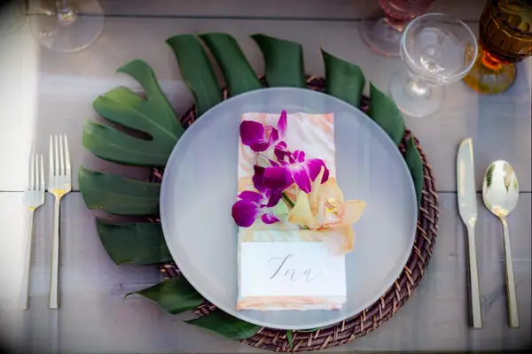 Tropical place setting with monstera leaf charger and orchid accents