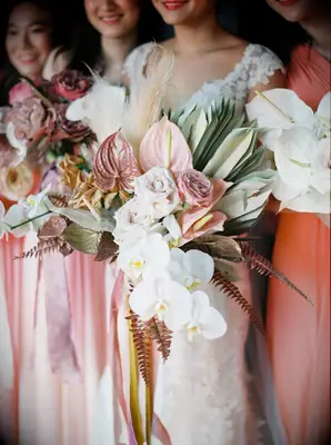 Bouquet with pink anthurium, white orchids and dried palm leaves
