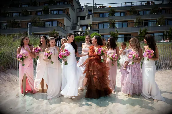 Bridal party wearing various dresses in pink and red shades