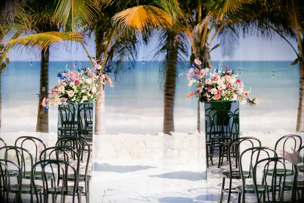 Beach ceremony with mirrored flower pedestals