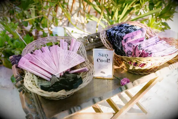 Pink and black fans and handkerchiefs for beach wedding guests