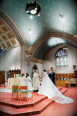 Bride and groom at altar in cathedral with fern and floral decor