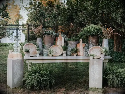 wedding seating chart written on mix-and-match terracotta pots filled with greenery