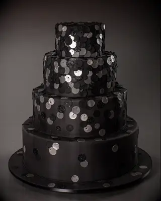 Three-tiered black wedding cake with sequin details. 