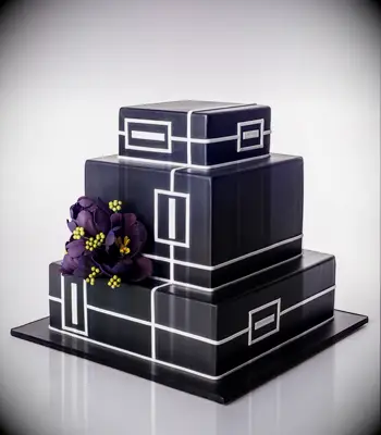 Square three-tier black wedding cake with art deco detailing. 