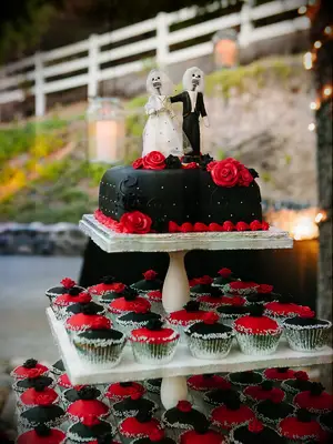 Small black wedding cake with black and red cupcakes