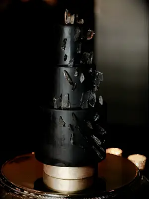 Three-tier black wedding cake with geode decorations