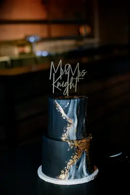 Black marble wedding cake with custom topper. 