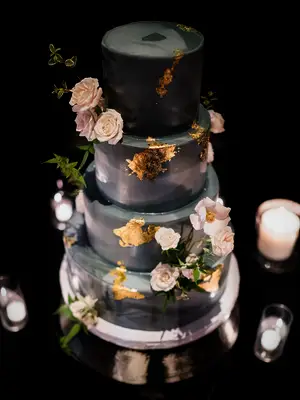 Black and gray ombré wedding cake with flowers and gold leaf foil