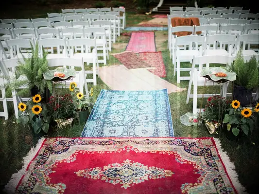 Colorful bohemian rugs used as wedding aisle runners. 