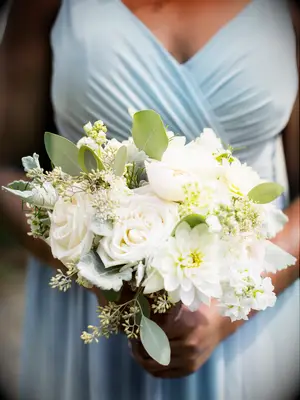 This small wedding bouquet showcases roses, dahlias, and delicate greenery.