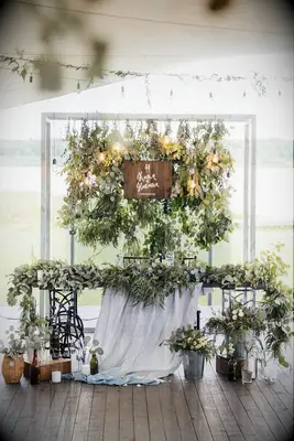 simple wedding sweetheart table decor with bundles of eucalyptus as a backdrop and greenery garland along the front of the table