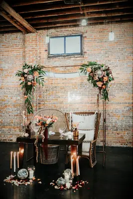 indoor wedding sweetheart table decorated with chuppah and tallit from wedding ceremony