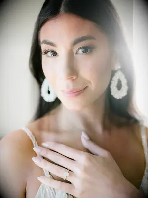 brunette bride with natural makeup, pearl drop earrings and nude oval shaped nails