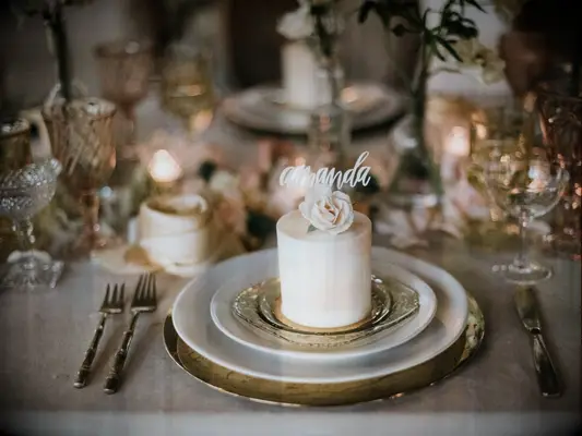 luxury wedding place setting featuring miniature one-tier cake decorated with amanda cake topper in lieu of place card