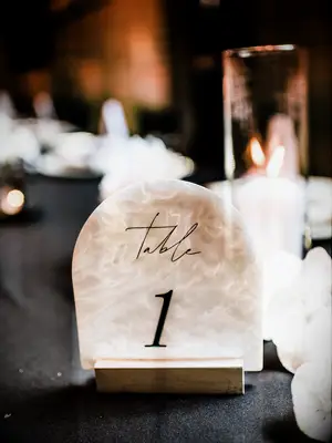 rounded acrylic wedding table number with marbled beige and white iridescent design
