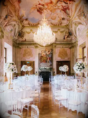 luxury wedding venue historical estate ballroom with painted ceiling, ornate crown molding and crystal chandelier in the center of the room