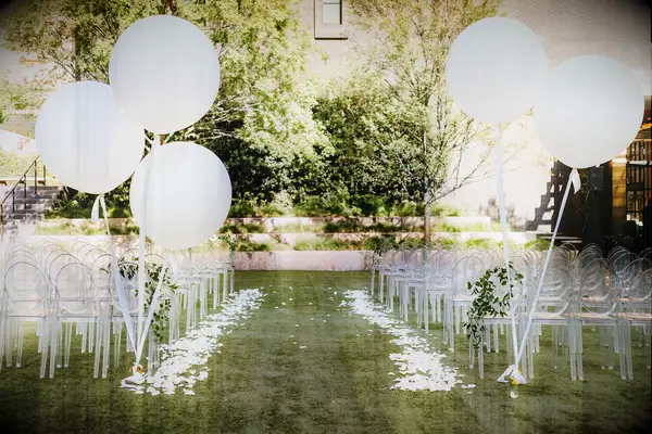 affordable wedding decor idea oversized white balloons decorating the wedding ceremony aisle entrance
