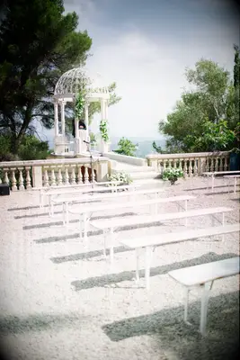 outdoor wedding ceremony overlooking mountaintop with white benches as seating