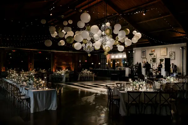 affordable wedding reception decor idea with paper lanterns in different sizes and colors hanging above the dance floor