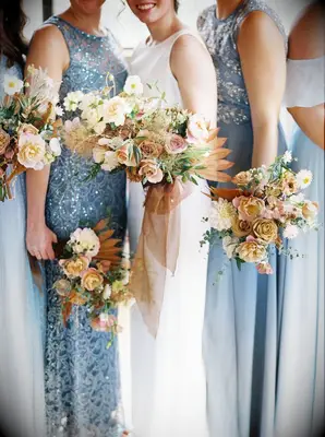 Bridesmaids in blue dresses holding yellow bouquets